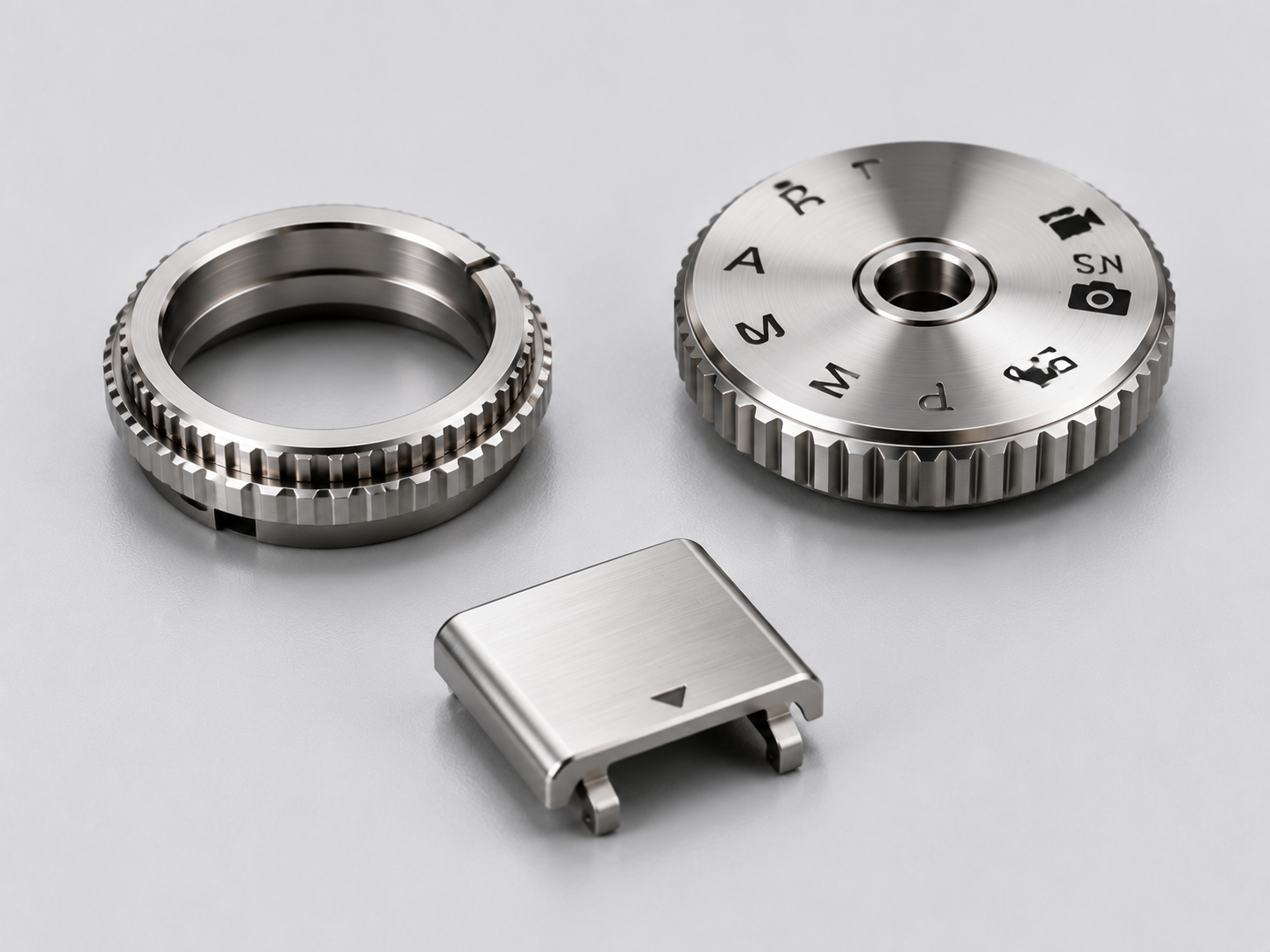 Precision digital camera components including a control dial, mode dial, and hot shoe cover made with advanced amorphous alloy materials
