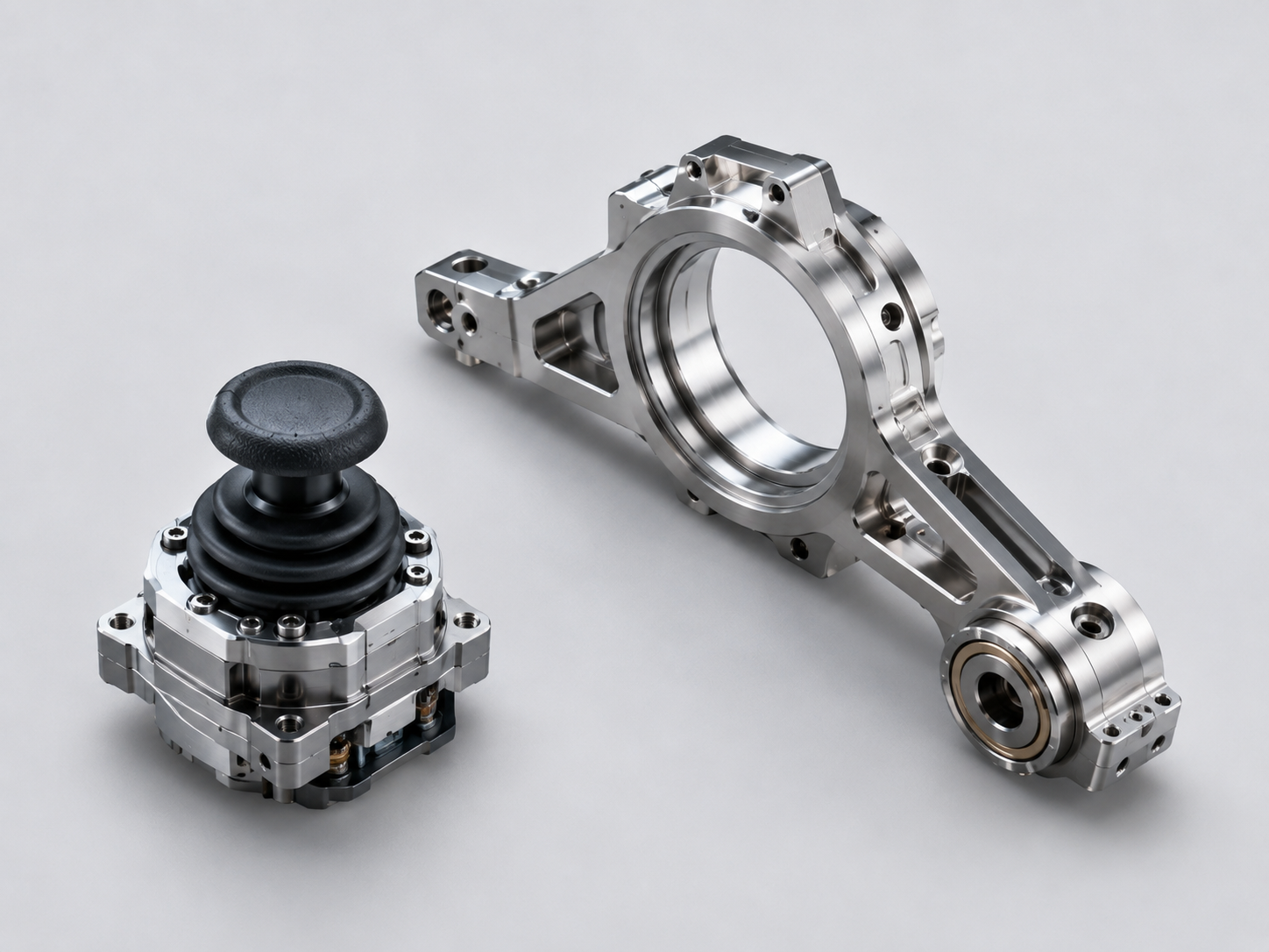 Precision handheld gimbal components including a joystick assembly and pitch-axis bracket made with advanced amorphous alloy materials