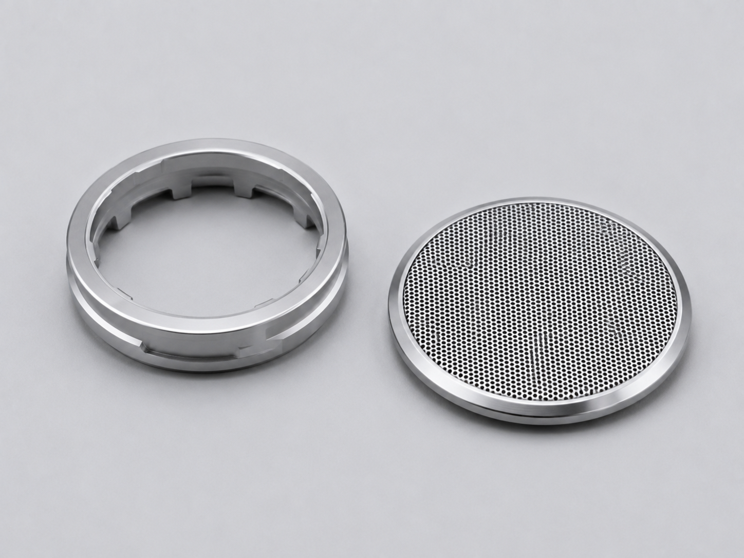 Precision portable speaker components including a passive radiator weight ring and decorative mesh grille made with advanced amorphous alloy materials